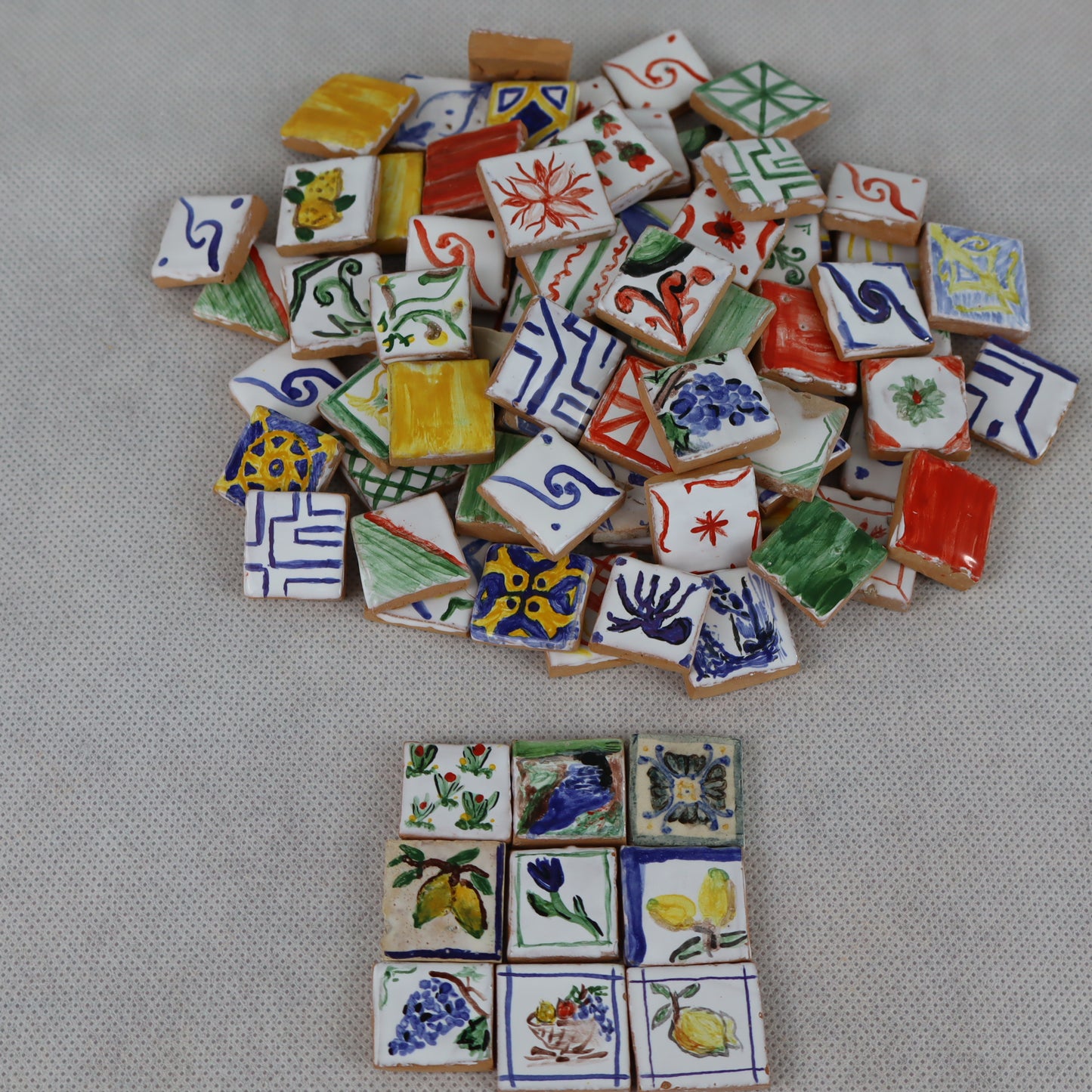Mucchietto di pregiate piastrelle in miniatura 2×2 cm , interamente decorate a mano , ideali per arricchire pavimentazioni, rivestimenti o dettagli artistici in presepi, diorami, case di bambola e plastici architettonici .