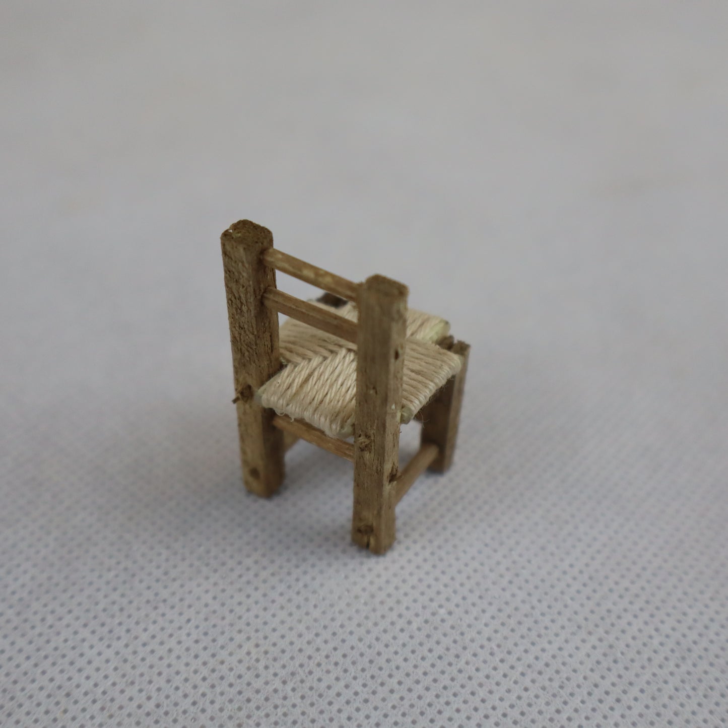 Piccola sedia in miniatura realizzata a mano in legno grezzo, con seduta intrecciata in paglia naturale.
Con un'altezza di circa 4 cm e una larghezza di 2 cm, è ideale per arricchire ambientazioni in scala ridotta come presepi artigianali, diorami rurali e scenografie tradizionali.