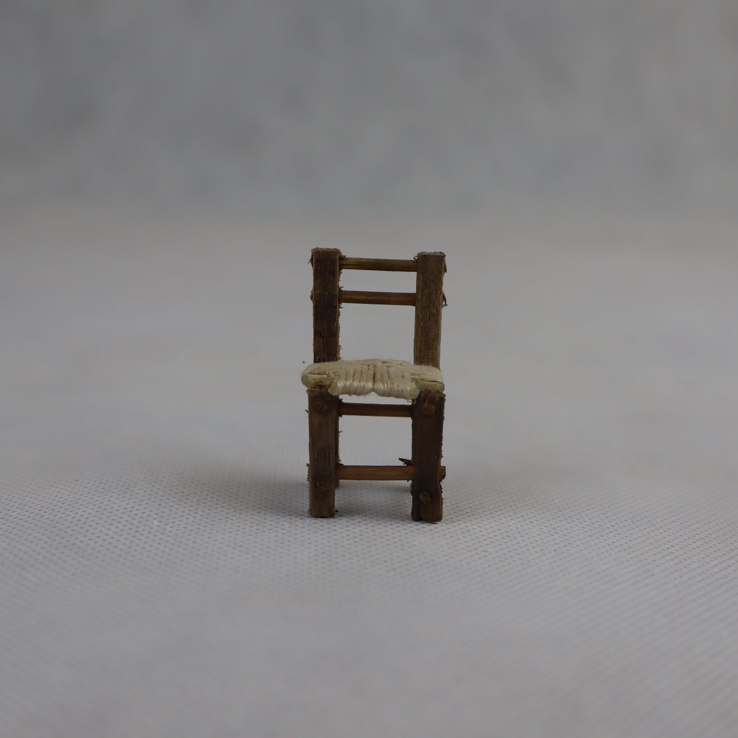 Piccola sedia in miniatura realizzata a mano in legno grezzo, con seduta intrecciata in paglia naturale.
Con un'altezza di circa 4 cm e una larghezza di 2 cm, è ideale per arricchire ambientazioni in scala ridotta come presepi artigianali, diorami rurali e scenografie tradizionali.
