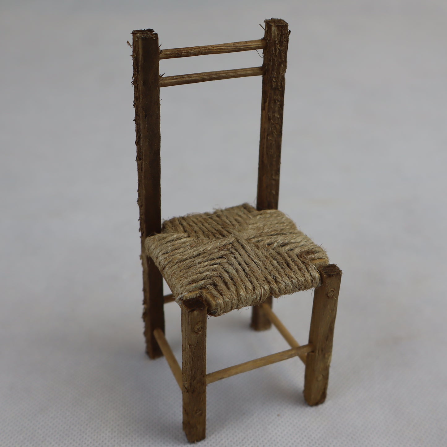 Sedia in miniatura realizzata in legno grezzo con seduta intrecciata in paglia naturale.
Le sue dimensioni contenute (circa 12 cm di altezza e 5 cm di larghezza) la rendono perfetta per arredare scene rustiche in presepi, diorami, plastici architettonici o ambientazioni ispirate alla vita contadina.
