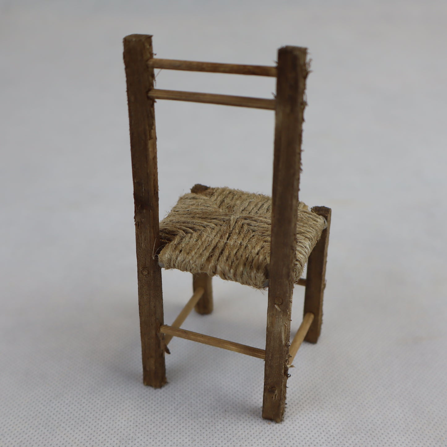 Sedia in miniatura realizzata in legno grezzo con seduta intrecciata in paglia naturale.
Le sue dimensioni contenute (circa 12 cm di altezza e 5 cm di larghezza) la rendono perfetta per arredare scene rustiche in presepi, diorami, plastici architettonici o ambientazioni ispirate alla vita contadina.