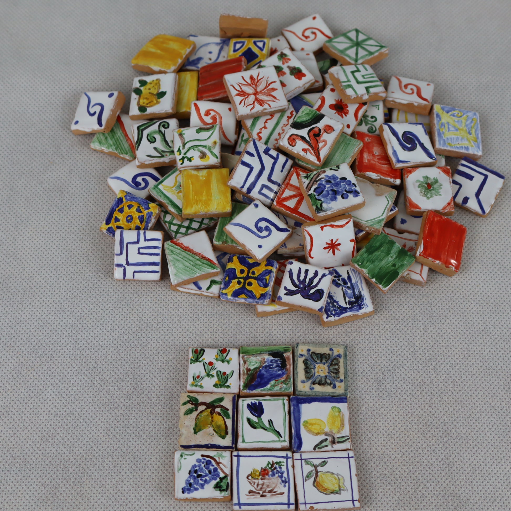 Mucchietto di pregiate piastrelle in miniatura 2×2 cm , interamente decorate a mano , ideali per arricchire pavimentazioni, rivestimenti o dettagli artistici in presepi, diorami, case di bambola e plastici architettonici .