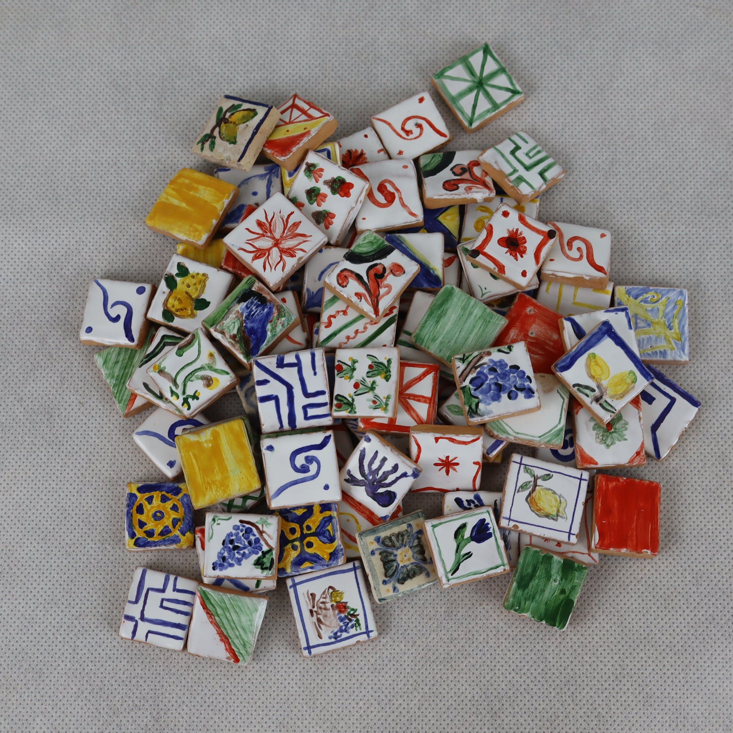 Mucchietti di pregiate piastrelle in miniatura 2×2 cm , interamente decorate a mano , ideali per arricchire pavimentazioni, rivestimenti o dettagli artistici in presepi, diorami, case di bambola e plastici architettonici .