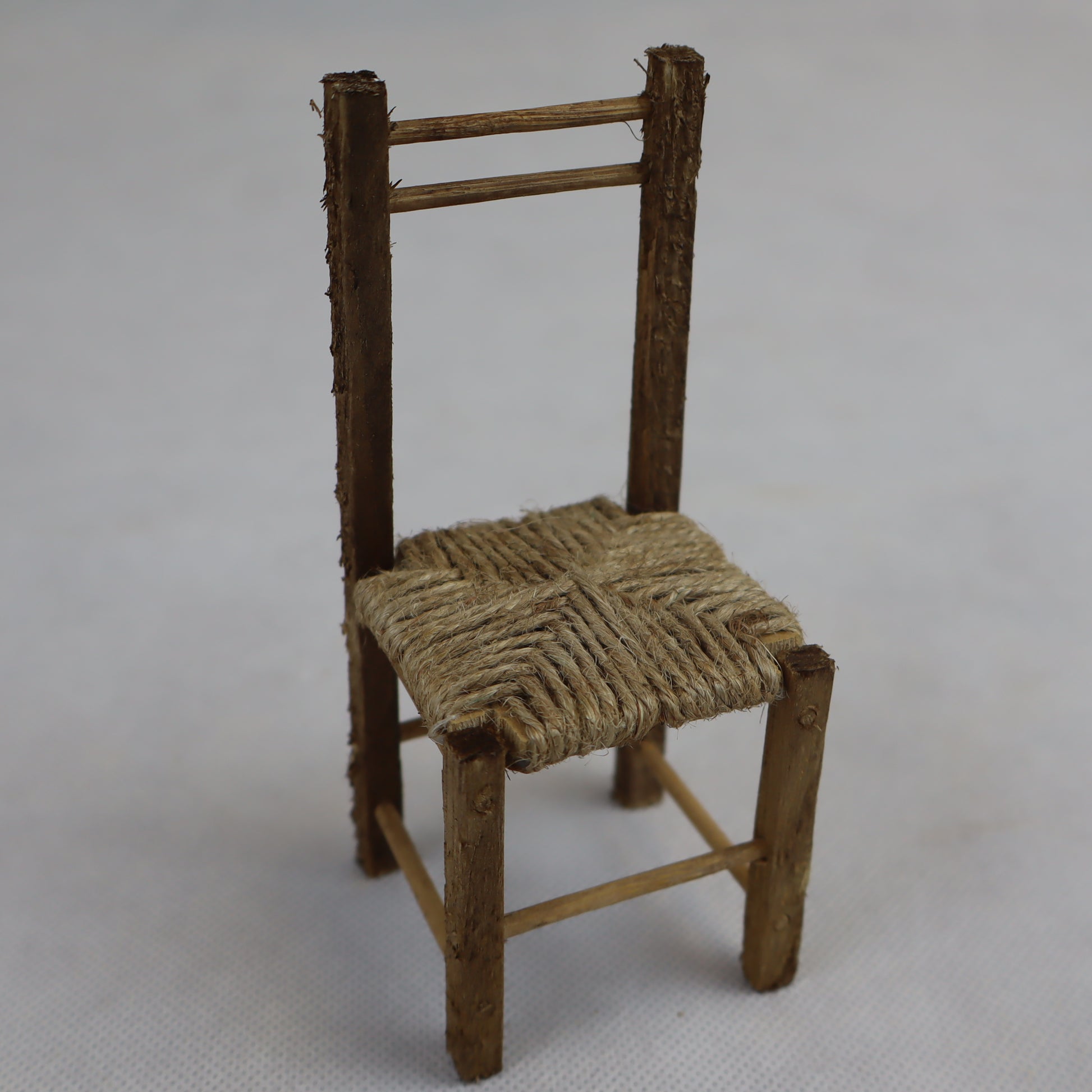 Sedia in miniatura realizzata in legno grezzo con seduta intrecciata in paglia naturale.
Le sue dimensioni contenute (circa 12 cm di altezza e 5 cm di larghezza) la rendono perfetta per arredare scene rustiche in presepi, diorami, plastici architettonici o ambientazioni ispirate alla vita contadina.