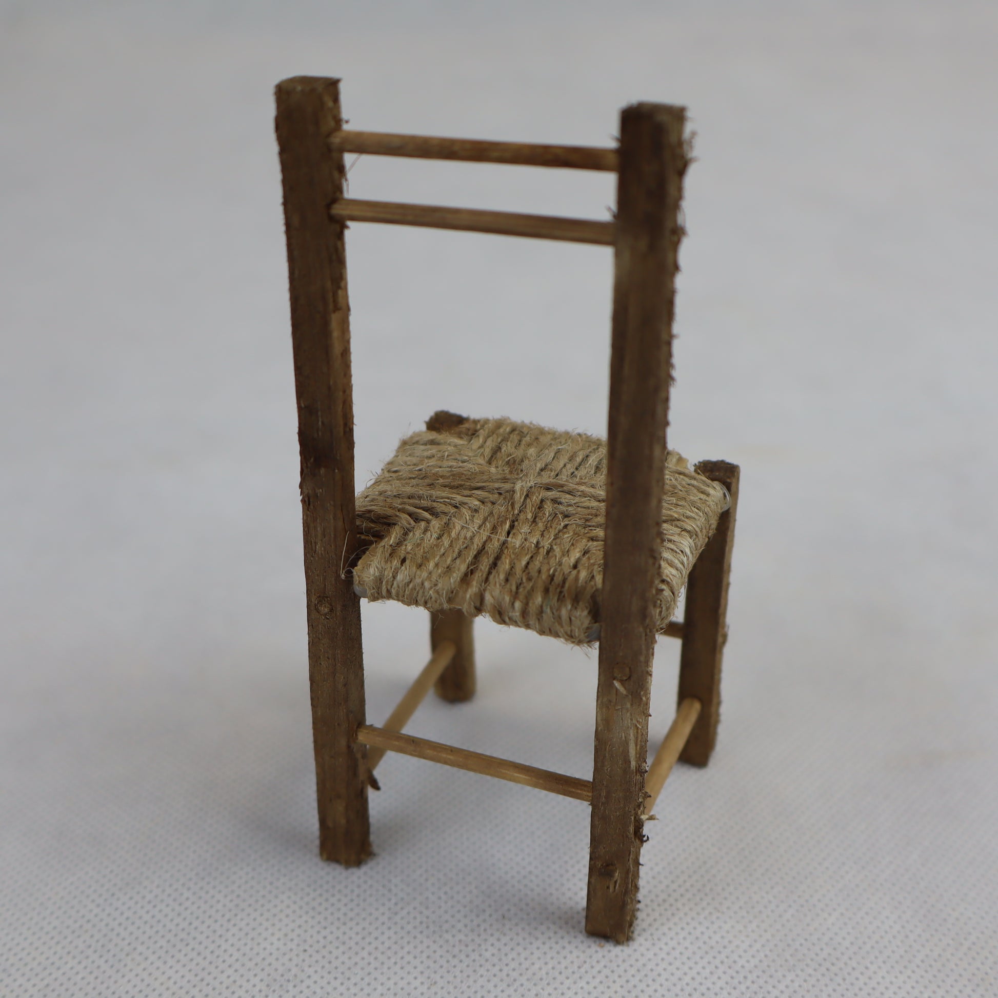 Sedia in miniatura realizzata in legno grezzo con seduta intrecciata in paglia naturale.
Le sue dimensioni contenute (circa 12 cm di altezza e 5 cm di larghezza) la rendono perfetta per arredare scene rustiche in presepi, diorami, plastici architettonici o ambientazioni ispirate alla vita contadina.