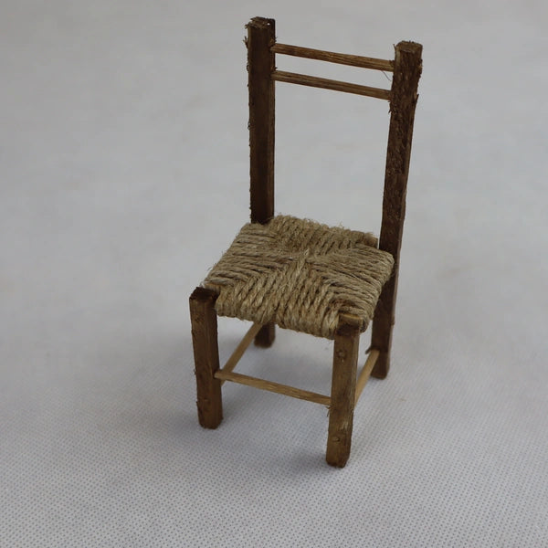 Sedia rustica in miniatura in legno grezzo e paglia naturale vista dall'alto